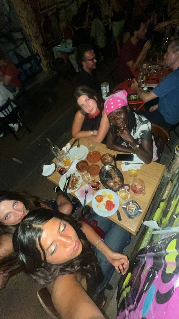 Friends around a table at night, taking a selfie from above