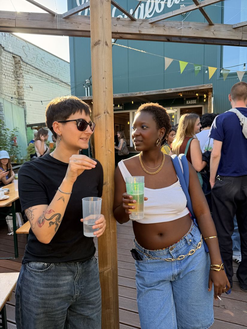 Two friends talking with drinks in a beer garden